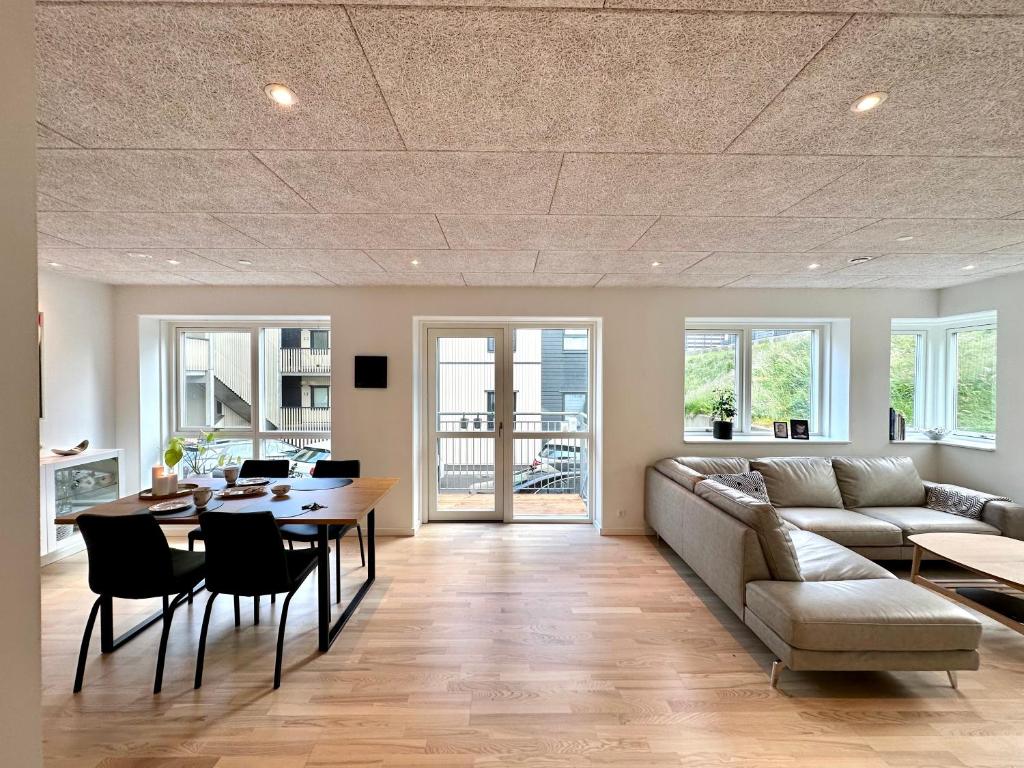 Luxury New Cozy and Quietly 95m2 في تورشافن: غرفة معيشة مع أريكة وطاولة وكراسي