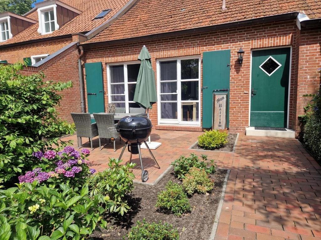 a bbq grill on a patio in front of a house at Ferienwohnung Baltrum auf dem Elisenhof Hagermarsch in Hagermarsch