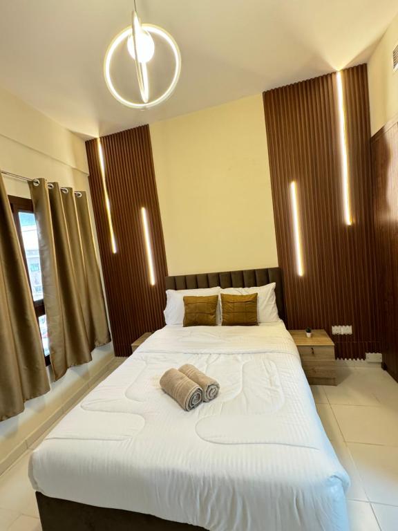 1 dormitorio con 1 cama blanca grande y 2 almohadas en RksHome Studio Apartment Baniyas Metro Exit 2, en Dubái