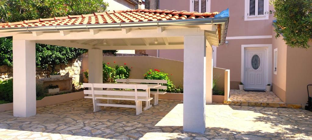 a pavilion with a bench and a table in front of a house at Country House in Čunski
