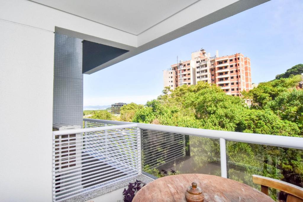balcón con mesa y vistas a un edificio en Apto 2 quartos, 350 mts Primavera Garden e ACM P2079, en Florianópolis