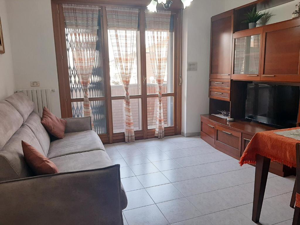een woonkamer met een bank en een flatscreen-tv bij Milano Linate Airport Apartment in Peschiera Borromeo