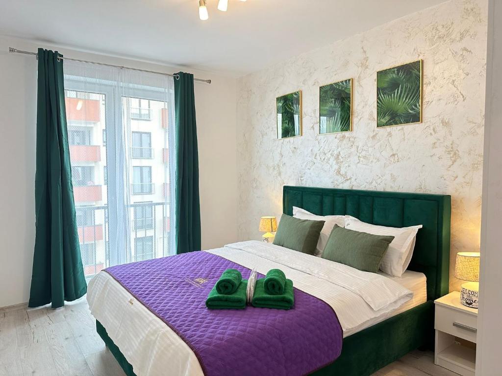 a bedroom with a bed with green shoes on it at Luxury Glam Apartments Sibiu near Station and Mall in Sibiu