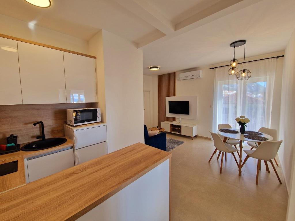 cocina y sala de estar con mesa y sillas en Apartment Ana - Gradac, en Gradac