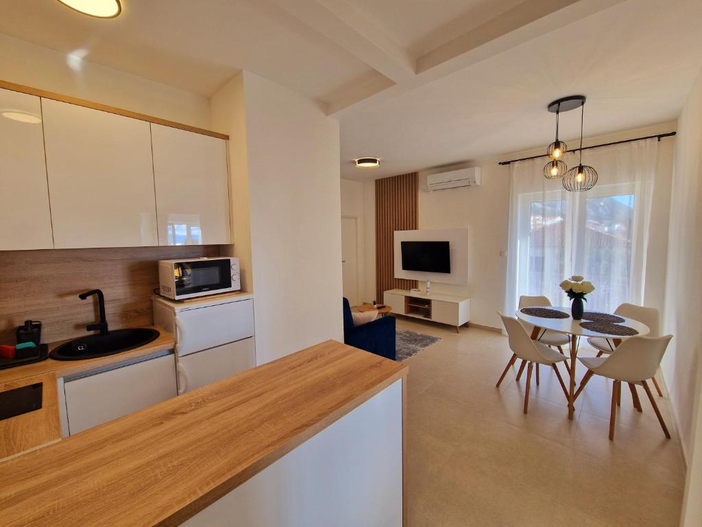 een keuken en woonkamer met een tafel en stoelen bij Apartment Ana - Gradac in Gradac