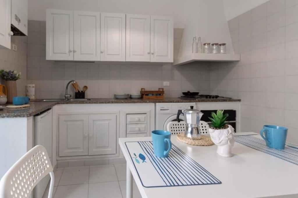 阿拉西奧的住宿－Apartment in Alassio - Ligurische Riviera 48200，厨房配有白色橱柜和白色的桌椅