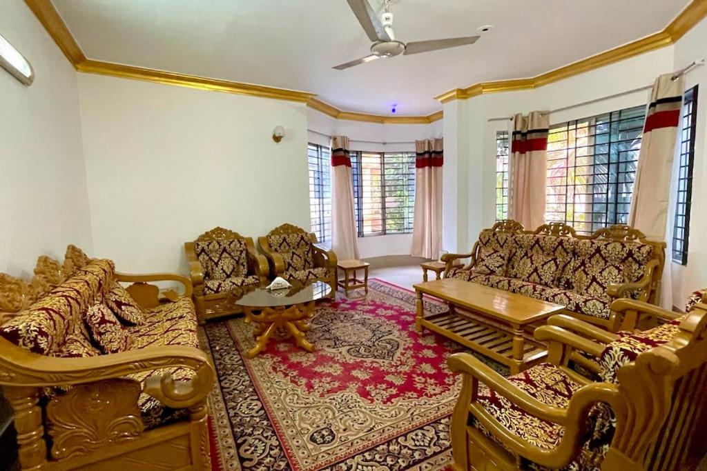 uma sala de estar com sofás e uma mesa em Kumar Para Deluxe Villa em Sylhet