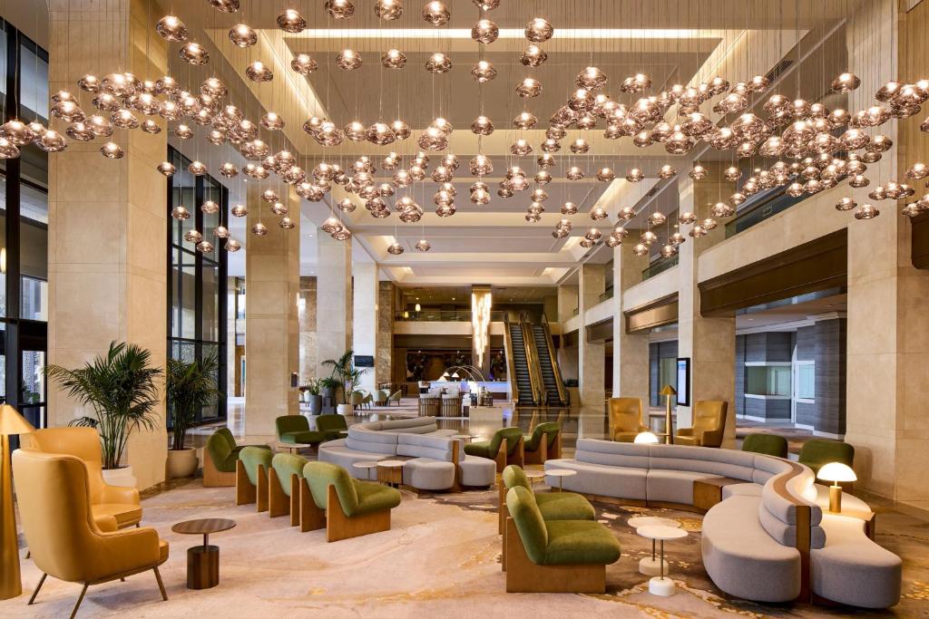 a lobby with couches and chairs and a chandelier at The Westin Los Angeles Airport in Los Angeles