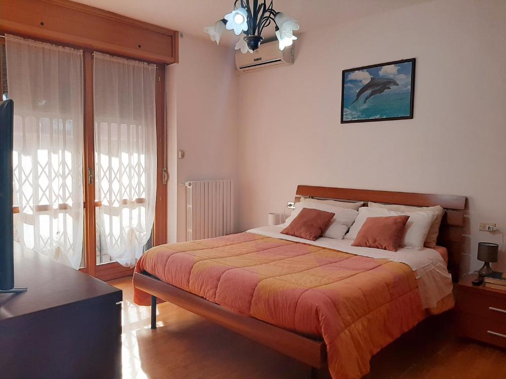a bedroom with a large bed with orange sheets at Milano Linate Airport Apartment in Peschiera Borromeo