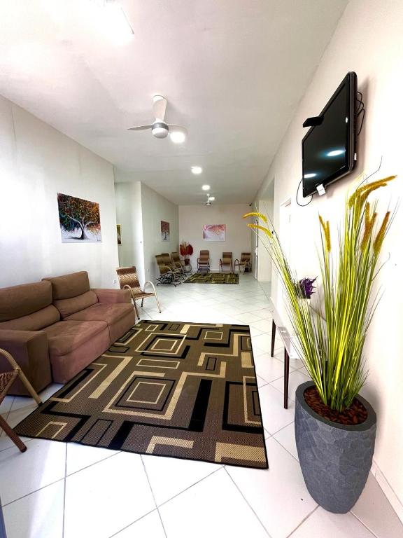 - un salon avec un canapé et une télévision dans l'établissement Hostel São João, à Araçariguama