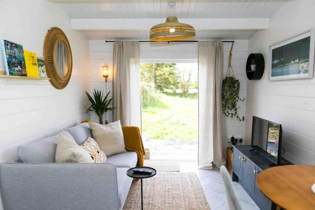 ein Wohnzimmer mit einem Sofa und einem TV in der Unterkunft The Apiary in Killarney