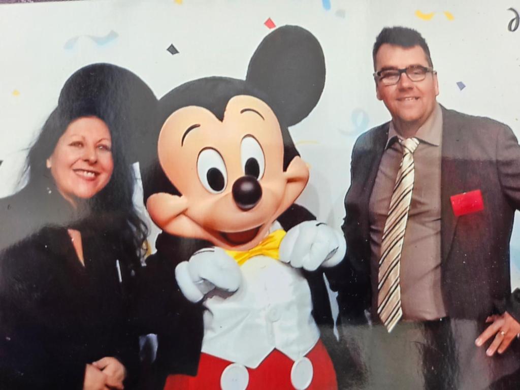 a man and a woman standing next to a mickey mouse mascot at chez christian&astrid Next to Disneyland Paris in Penchard