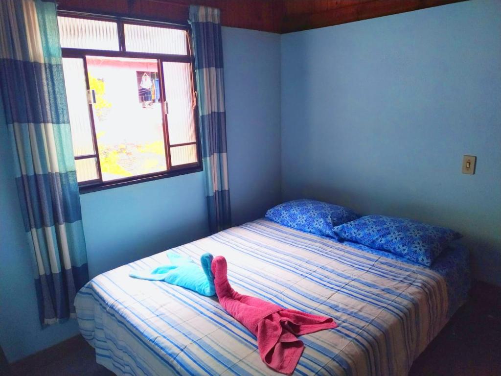 a bedroom with a bed with a stuffed animal on it at POUSADA DO BAR- BUDO in Visconde De Maua