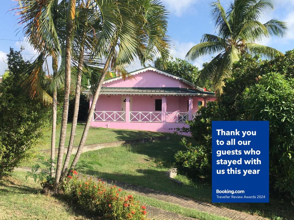 uma casa cor-de-rosa com um sinal que diz obrigado a todos os nossos hóspedes que ficaram em The Pink House em Choiseul