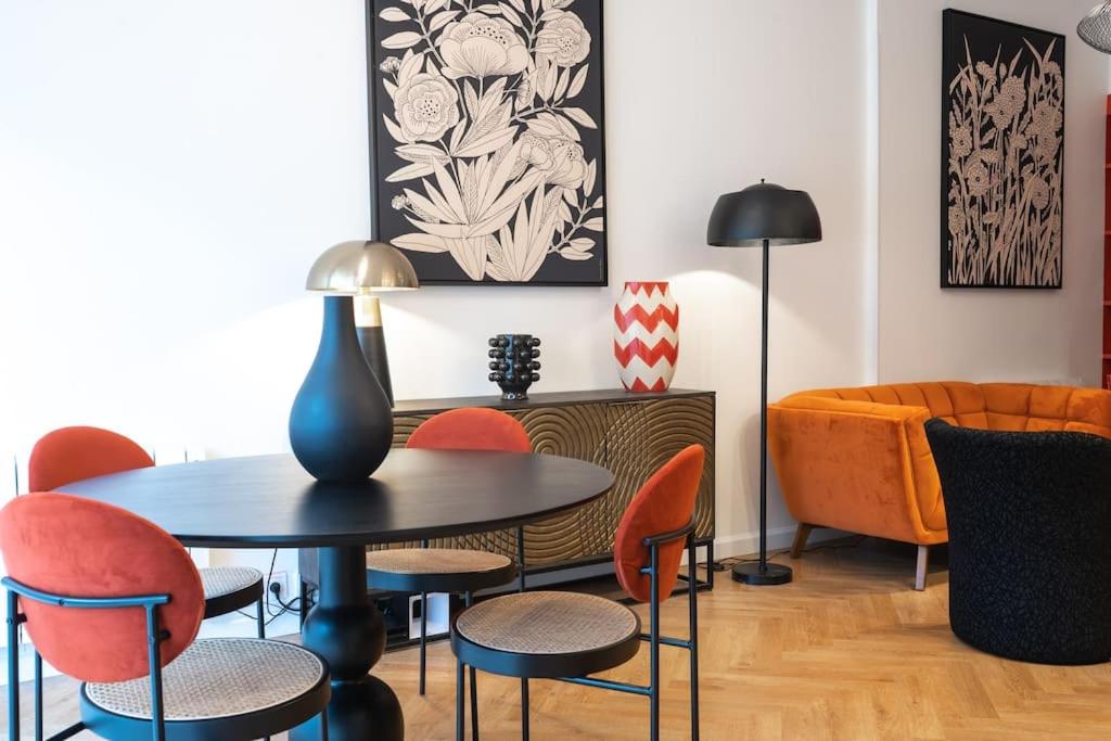 uma sala de jantar com mesa e cadeiras em E Fauvette appartement de standing avec terrasse em Épernay