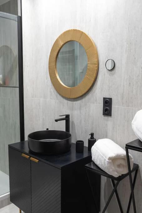 a bathroom with a black sink and a mirror at E Fauvette appartement de standing avec terrasse in Épernay
