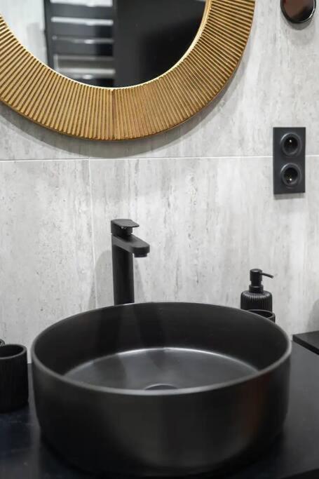 a black sink in a bathroom with a mirror at E Fauvette appartement de standing avec terrasse in Épernay