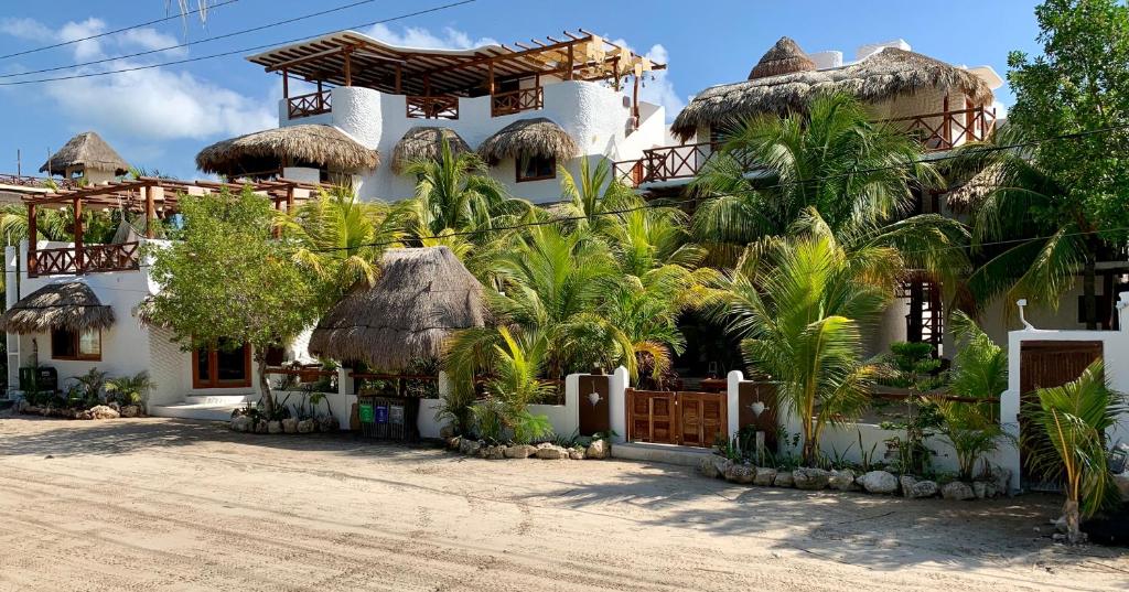 una casa con un montón de palmeras delante de ella en El Corazón Boutique Hotel - Adults Only with Beach Club's pass included, en Isla Holbox