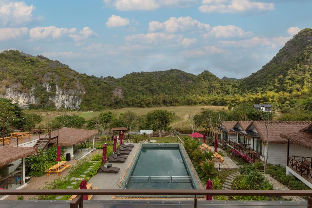 a view of a resort with a swimming pool and mountains at YEN Hidden Valley in Cat Ba