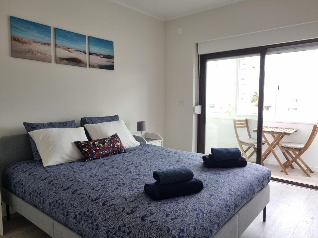 1 dormitorio con 1 cama con 2 almohadas en Beach Apartment w/Ocean view en Costa da Caparica