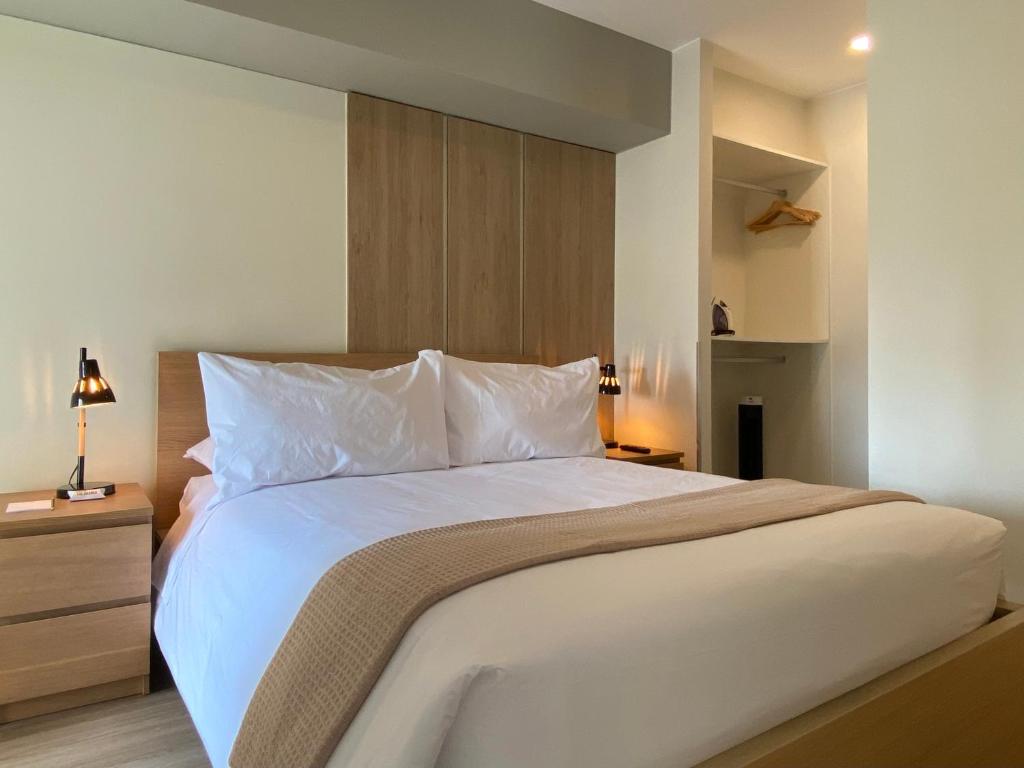 een slaapkamer met een groot bed met witte lakens en kussens bij La Mar Miraflores by Wynwood House in Lima
