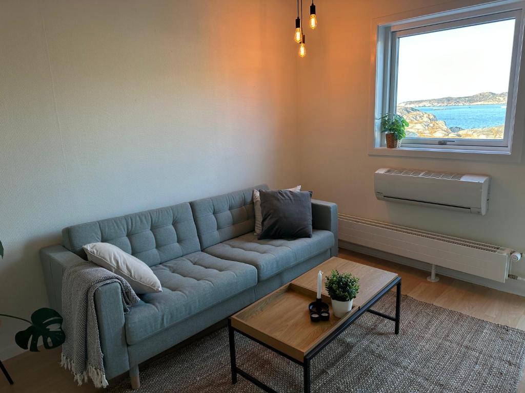 a living room with a blue couch and a table at Modern seaview house Ilulissat in Ilulissat