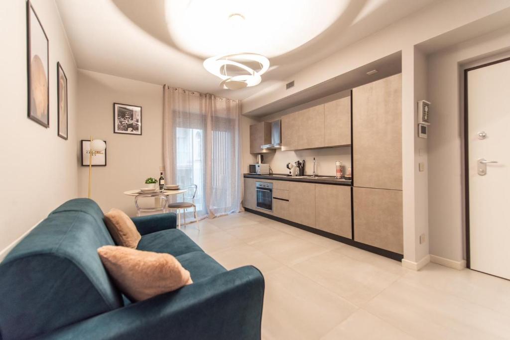 een woonkamer met een blauwe bank en een keuken bij Elegante Bilocale-Centro Torino-Free WiFi in Turijn