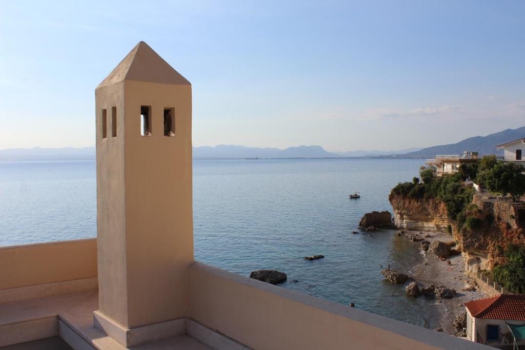 een balkon met uitzicht op de oceaan en een klokkentoren bij Avia Holiday Homes in Avía