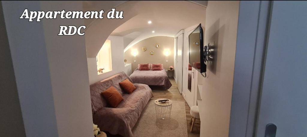 ein Wohnzimmer mit einem Sofa und einem Bett in der Unterkunft Au coeur du village de Vals in Vals-les-Bains