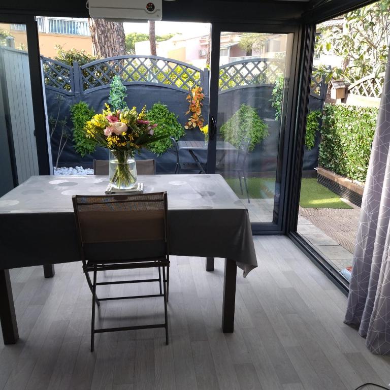 un vase de fleurs sur une table sur une terrasse dans l'établissement Appart au cœur des pins - 2 chambres - 6 personnes-clim-parking, au Cap d'Agde