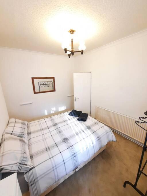 een slaapkamer met een bed en een plafond bij Basic 5-bedroom home - Affordable accommodation for groups in Swansea