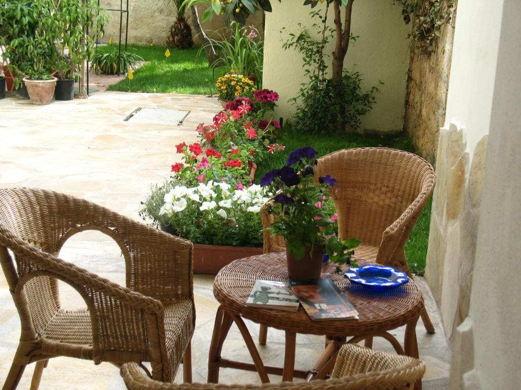 una mesa y sillas con flores en el patio en Il Giardinetto, en Alghero