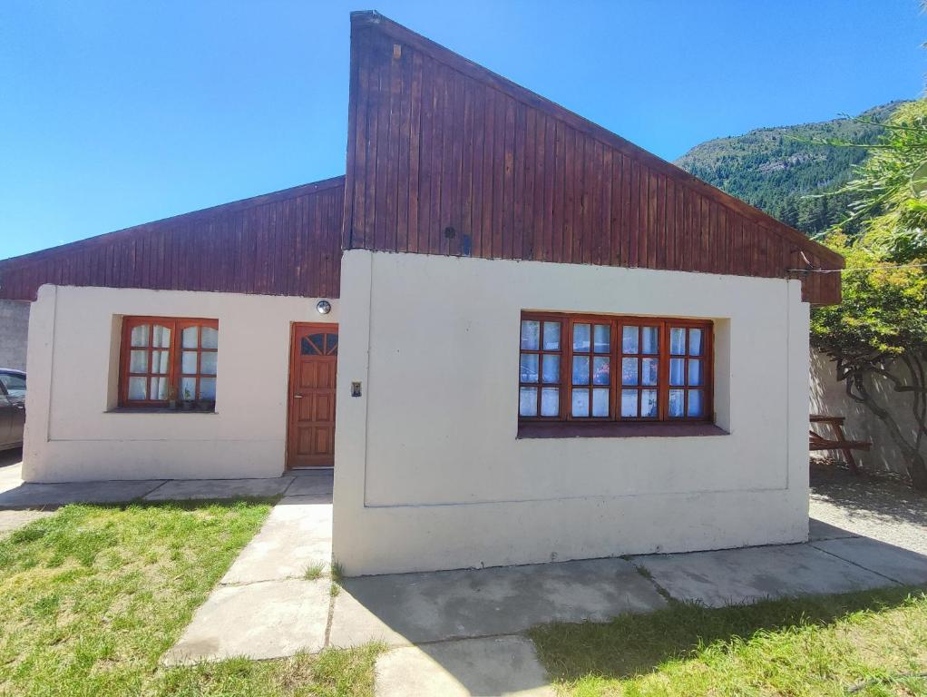 a white building with a red roof at Departamento en el centro in Lago Puelo