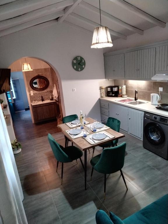 a kitchen with a wooden table and green chairs at Litsa's House Platanias in Agia Paraskevi