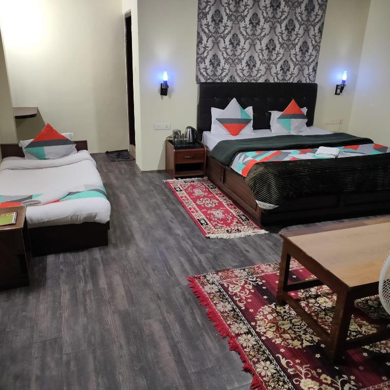 a hotel room with two beds and a couch at HOTEL TASHI NORLING Near Mall Road in Gangtok