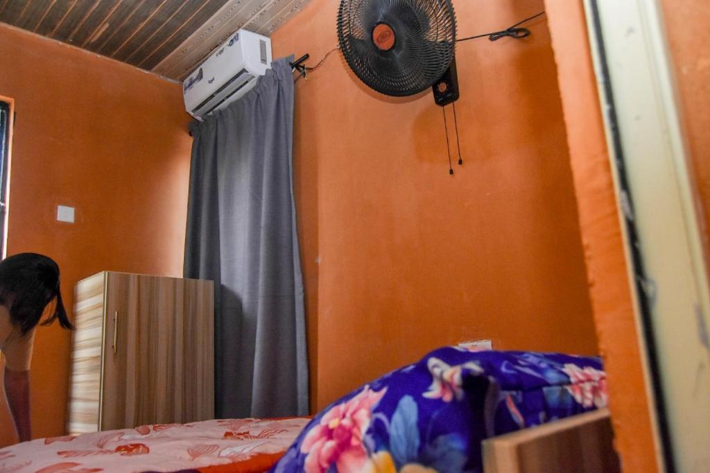 More Point Lounge في Ikorodu: غرفة نوم بسرير ومروحة على الحائط