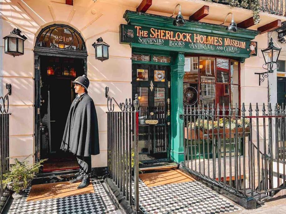 un hombre está parado frente a una tienda en Baker st / Marylebone / Sherlock Holmes 3Bed2Bath, en Londres