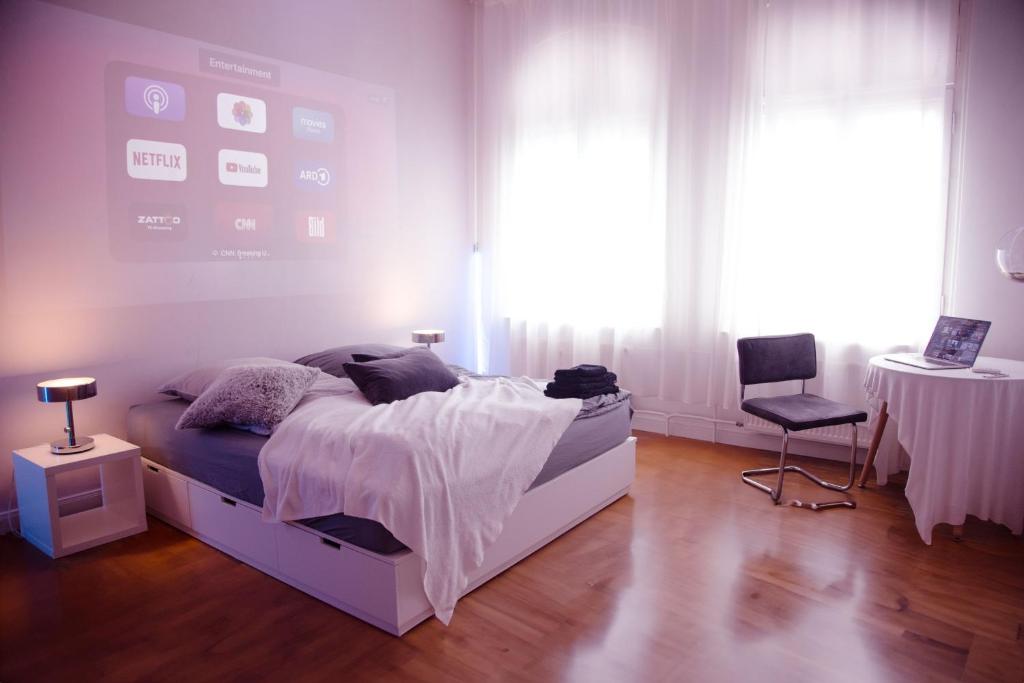 a bedroom with a bed and a table and a chair at Huge Apartment with Home Cinema and Kitchen in Friedrichshain in Berlin