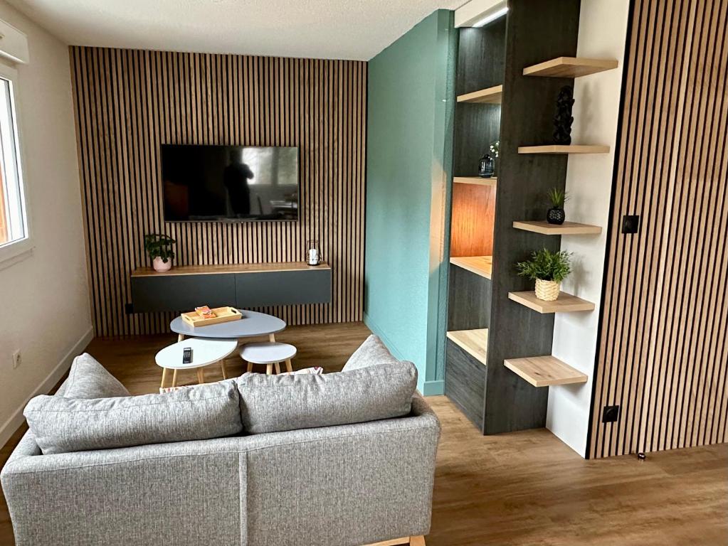 a living room with a couch and a table at Le 150 appartement au centre in Les Rousses