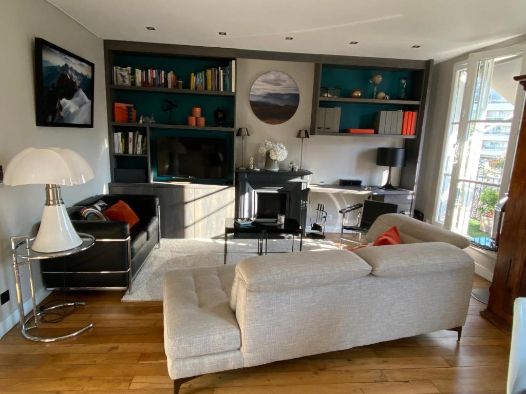 un salon avec un canapé et une télévision dans l'établissement Montparnasse Paris 15, à Paris