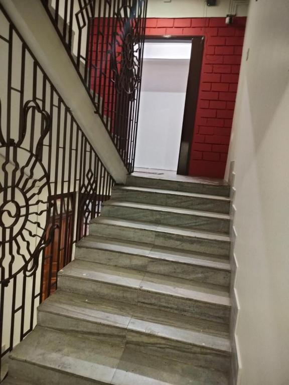 a staircase with a wrought iron railing and a door at HOTEL TASHI NORLING Near Mall Road in Gangtok