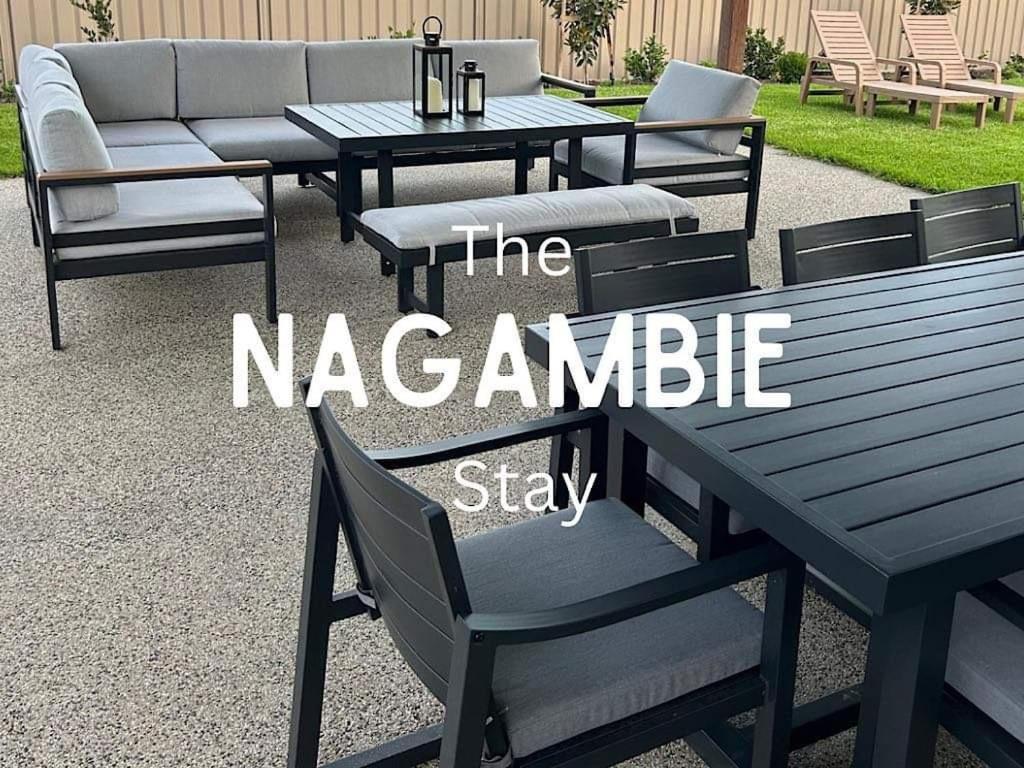 een houten picknicktafel en stoelen met de woorden van het nazamble verblijf bij The Nagambie Stay in Nagambie