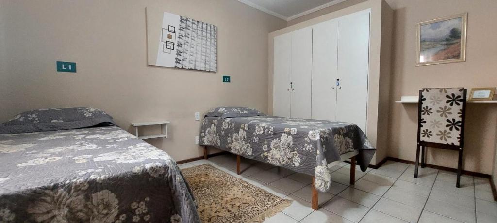 a hospital room with two beds and a cabinet at Pousada Palmeira in Viracopos
