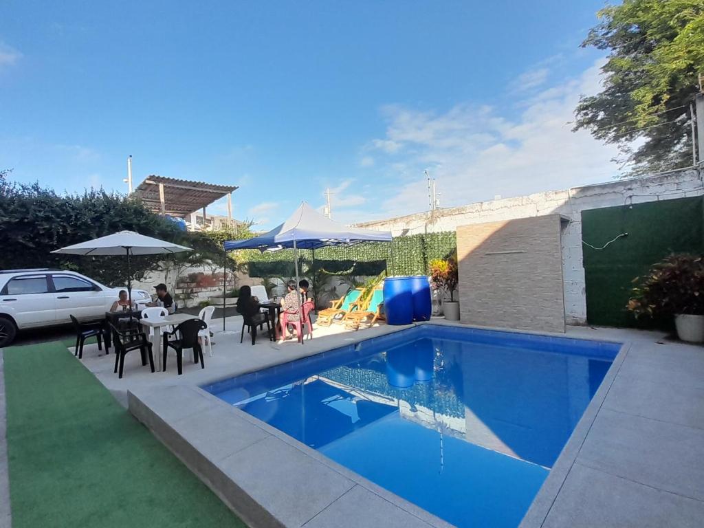 einen Pool im Hinterhof mit einem Tisch und Stühlen in der Unterkunft HOSTAL SAN MARINO in Manta
