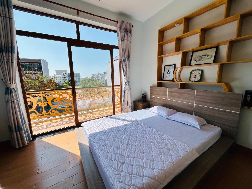 a bedroom with a large bed and a large window at Lộc Vừng Homestay in Phan Thiet