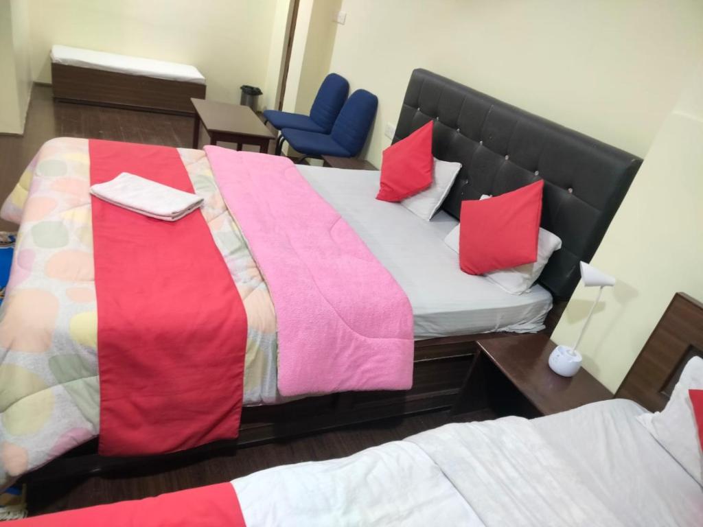 a hotel room with two beds and a blue chair at HOTEL TASHI NORLING Near Mall Road in Gangtok