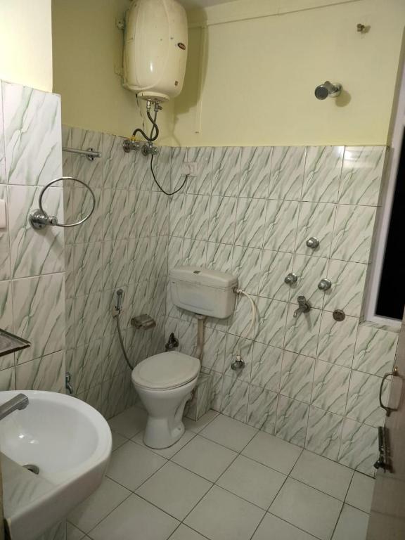 a bathroom with a toilet and a sink at HOTEL TASHI NORLING Near Mall Road in Gangtok