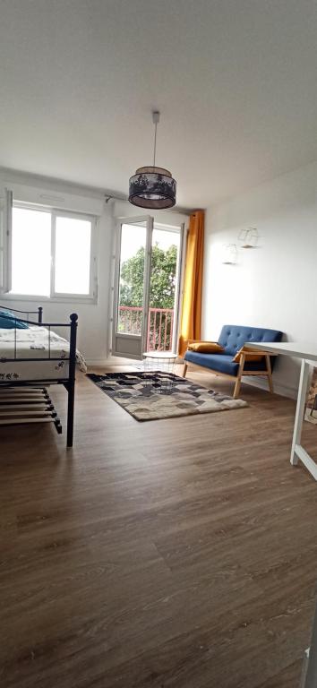 uma sala de estar com uma cama e um sofá em Appartement cosy route des plages em Lorient