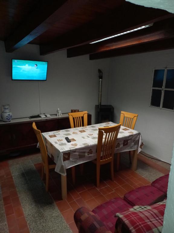 a dining room with a table and chairs and a tv at Casa Serrana in Penhas da Saúde