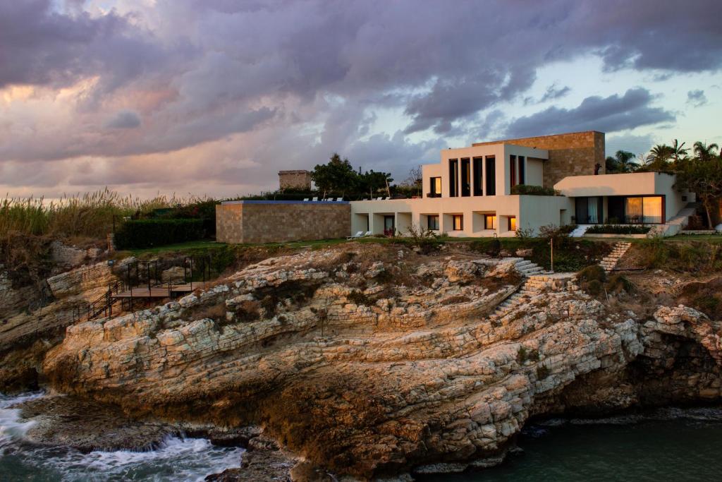 une maison sur une falaise à côté de l'eau dans l'établissement Zita Fidar, à Al Fīdār